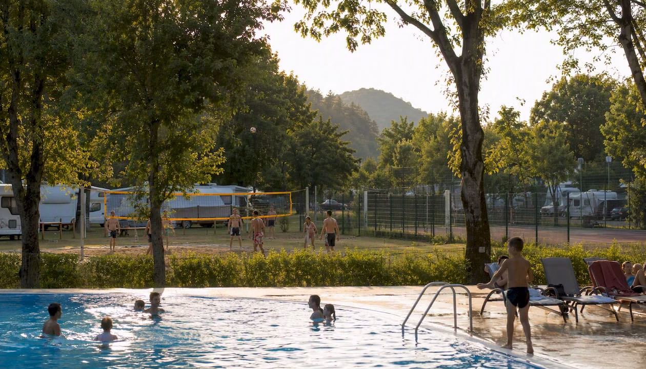 Large swimming pool and sports area at a campsite in Slovenia, ideal for an active holiday and relaxing outdoors.